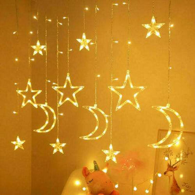 LED fairy string curtain lights with hanging stars and crescent moons glowing warm white indoors